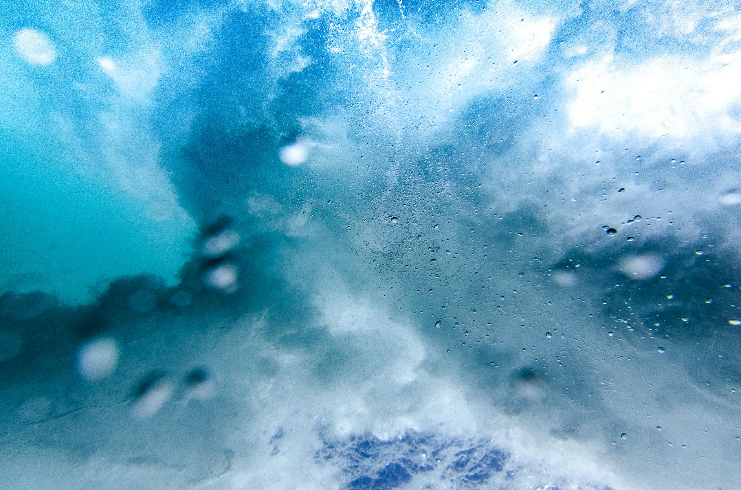 Captivating underwater view of an ocean wave bursting with vibrant blue textures and motion.
